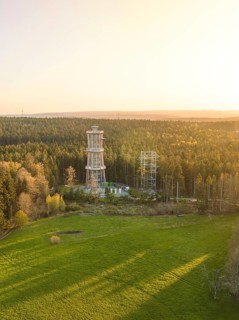 Tower in open area with forests at sunset, sky in evening light, observation tower Himmelsglück