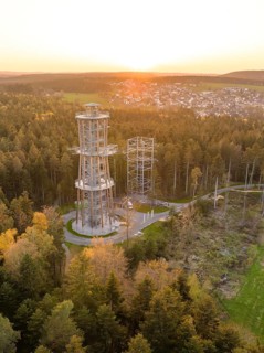 Tower in the forest at sunset, a village visible in the distance, Himmelsglück observation tower