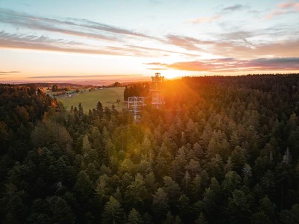Sunset over a large forest with visible observation tower, Himmelsglück observation tower with