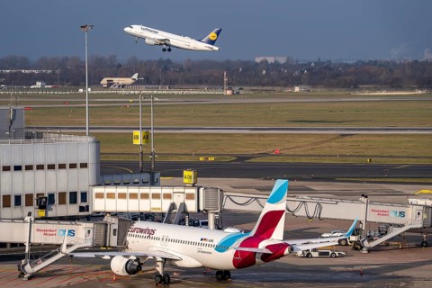 Düsseldorf airport, DUS, terminal A Eurowings aircraft at the gate, Lufthansa Airbus taking off