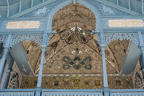 Detail of a richly decorated blue façade with symmetrical patterns, old villa villa of