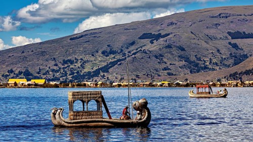 Two reed boats on a lake surrounded by mountains and a clear sky, The floating reed islands of the