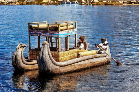 People on a large reed boat on a lake, dressed traditionally, The floating reed islands of the Uros