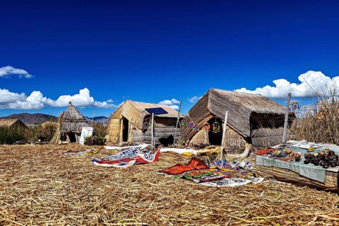 Straw huts on an island with traditional handmade objects in the foreground, The floating reed
