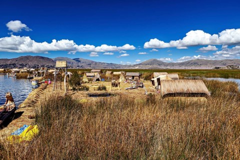 Natural environment with reed huts and mountains under blue skies, the floating reed islands of the