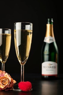 Two glasses on a black background with roses and a red heart