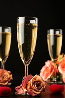 Three glasses with roses and hearts, dark background