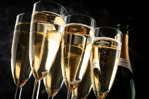 Champagne glasses and a champagne bottle against a black marbled background