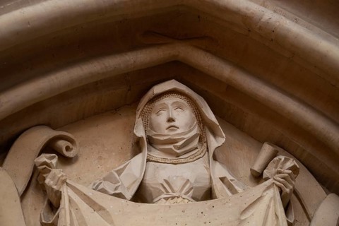 Woman in medieval clothing holding cloth with the face of Christ, stone figure, choir room,