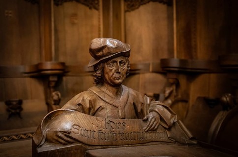 Carved half-figure, man with headdress, oak choir stalls for monks' hour prayers, 1493 by Jörg