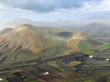 View of Montaña Tesa volcano from Montaña Blanca mountain with cloudy sky, Lanzarote, Canary