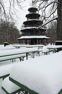 Winter in the English Garden, snow-covered beer garden tables and benches, Chinese Tower, Munich,