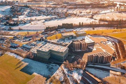 Industrial area with snow-covered fields and buildings from a bird's eye view, Hallwangen,