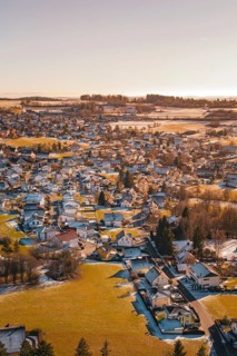 Village in winter with isolated snow-covered houses and fields, surrounded by trees, Hallwangen,