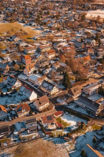 Bird's-eye view of city with snow-covered roofs in winter at sunset, Hallwangen, Freudenstadt