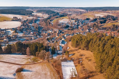 Extensive winter landscape with a village and surrounding fields under clear skies, Aach,