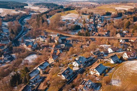 Snow-covered village spread over vast countryside with roads and forests, Aach, Dornstetten,