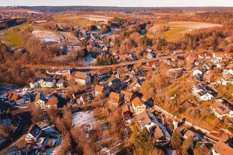 Snowy village spread over rolling hills with a clear view of the surrounding area, Aach,