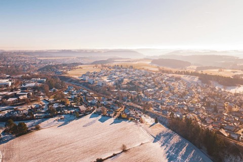 Aerial view of a snowy village in hilly landscape under bright sky, Aach, Dornstetten, Freudenstadt