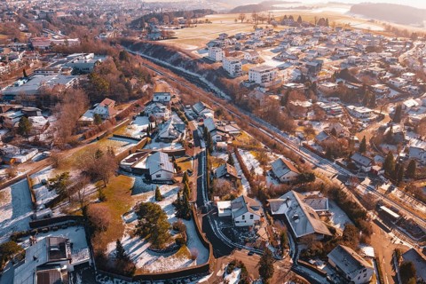 Village area with residential buildings under a light layer of snow in the morning sun,