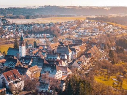 City view from the air with church and greenery, surrounded by rural landscape, Dornstetten,