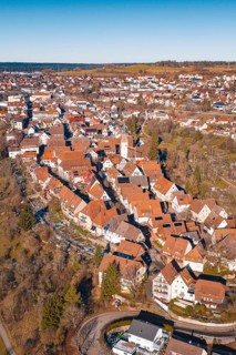 Aerial view of dense buildings with red roof tiles in a wintry environment, Dornstetten,