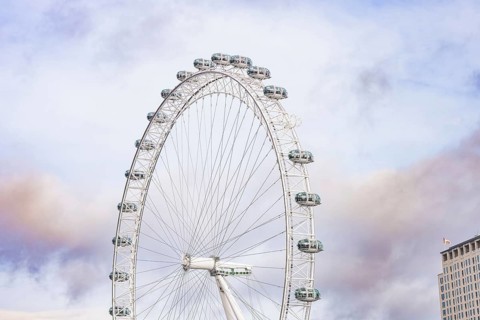 A large Ferris wheel stretches high over an urban backdrop, London Eye, London, United Kingdom