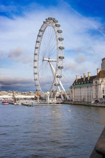 City view with Ferris wheel and river under cloudy sky, London Eye, London, United Kingdom