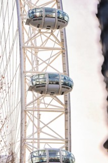 Close-up of a Ferris wheel with futuristic cabins against a bright sky, London Eye, London, United