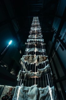 Tall vertical installation with metal and fur elements in a dark room, Tate Modern of Art, Lodon,