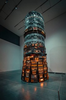 A tall tower of stacked radios with illuminated elements in the museum, Tate Modern of Art, Lodon,