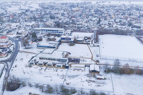 Modern and traditional buildings in a snowy village with streets and squares, Empfingen,