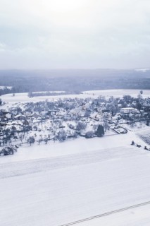 Snowy village in winter landscape with fields and trees, Wiesenstetten, Freudenstadt district,
