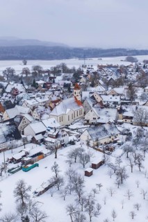 Snowy village with church in the center, surrounded by trees, winter landscape, Wiesenstetten,