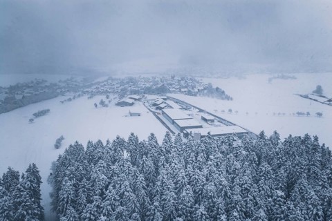 Aerial view of a snowy village surrounded by forests, Hörschweiler, Freudenstadt district, Germany
