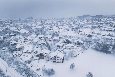 A village in winter rest, the houses are surrounded by snow and fog, Schopfloch, Freudenstadt