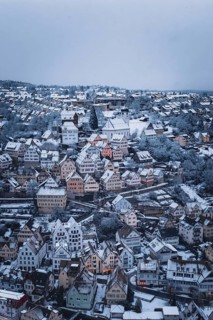Snowy town with half-timbered houses and church, surrounded by winter landscape, Altensteig, Calw