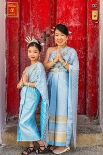 Mother and daughter in traditional clothing present themselves for the photographers, Wat Arun