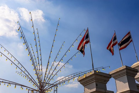 Rods with light bulbs and Thai flags against a blue sky, Bangkok, Thailand's metropolis, Thailand