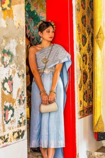 Young woman in traditional clothing presents herself to photographers, Wat Arun Buddhist temple,