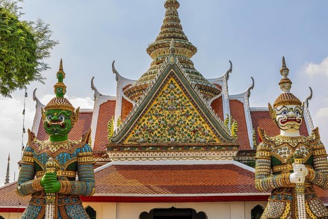 Wat Arun, guarded by mystical figures of Yaksha, Buddhist temple, overlapping roofs with Chedi
