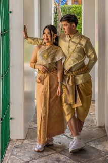 Young woman and young man in traditional clothing present themselves for the photographers, Wat