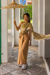 Young woman wearing a parasol in traditional clothing presents herself for the photographers, Wat