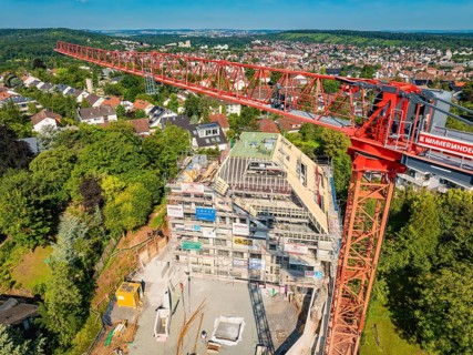 Large crane over a construction site with city panorama in the background, construction site of a