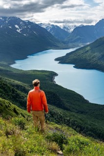 Mountaineer enjoys views of blue lake and mountains on Twin Peaks Trail, Eklutna Lake, Chugach