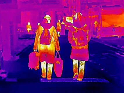 Thermal image or thermography, symbolic photo, interpolated. People traveling in urban areas.