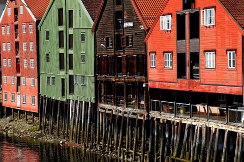 Colourful warehouses on pillars on the riverbank, Trondheim, Trøndelag, Norway