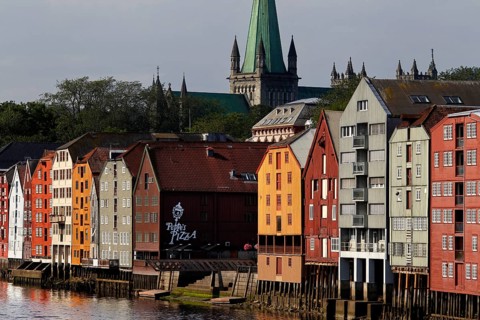 Storehouses on the Nidelva River with a view of Nidarosdomen, Trondheim, Trøndelag, Norway