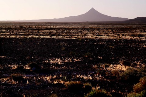 Volcano-like mountain rises from pristine desert landscape, Gourrama, Morocco