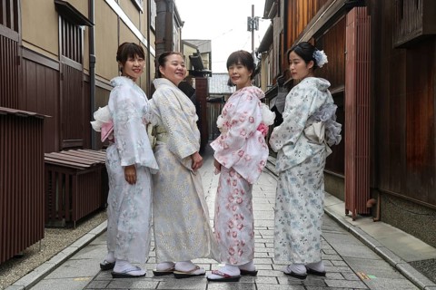 Four woman wearing kimonos pose on Nakamachi Street in Gion, Gion, Kioto, Japan